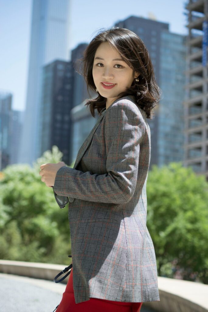 Woman in blazer, city backdrop